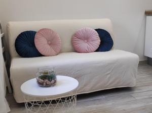 扎通马里拉吉客房旅馆的一张带桌子的沙发上配有两个粉红色和蓝色枕头