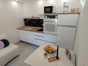 扎通马里拉吉客房旅馆的小厨房配有白色冰箱和桌子