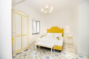 圣安吉洛Casale Guarracino的白色卧室配有一张大床和吊灯
