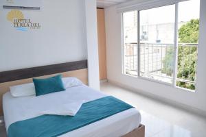 圣玛尔塔Hotel Perla del Caribe的一间卧室设有一张床和一个大窗户