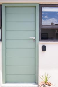 鲸湾港Avodation的一个带窗户的房子上的绿色车库门