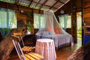 卡维塔Playa Grande Lodge & Tree House的卧室配有一张床和一张桌子