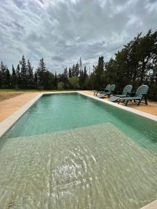 奇克拉纳－德拉弗龙特拉Agradable casa de campo con piscina en la Barrosa的一个带两把椅子的大型游泳池