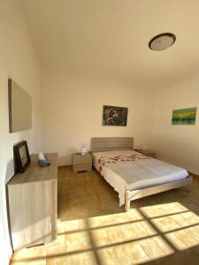 丽都玛里尼Appartamento "L'Ulivo" a Lido Marini的一间卧室配有一张床和一张桌子
