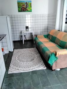 库亚巴Suíte 08 - Aconchegante e Exclusiva的一间设有床和一张桌子的房间,一张地毯