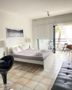 拉纳卡克拉萨斯海滩公寓的卧室配有一张床和一张桌子及椅子