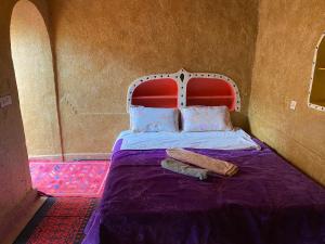 姆哈米德Dar Yaya的一张红色床头板的床和两张毛巾