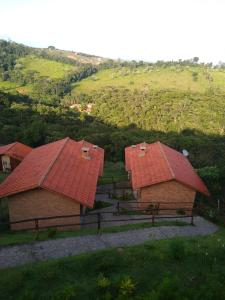 康塞高伊比蒂波卡CHALÉS DA ALÊ R do Céu nº 106的山上两个带红色屋顶的谷仓