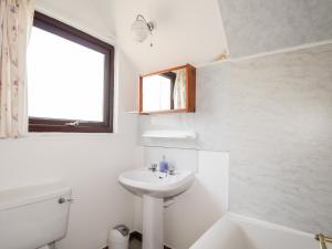 EdinbainGreshornish Boathouse的白色的浴室设有水槽和窗户。