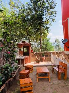 基多Hostal Casa San Fernando Tumbaco的庭院设有木长椅和树