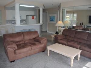 卡拉巴什Brunswick Plantation Golf Resort 1509M的客厅配有2张棕色沙发和1张桌子