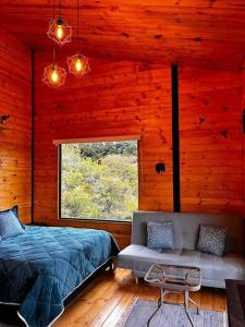 莱瓦镇Villa Skape - Finca Villa Carolina的一间卧室配有一张床、一张沙发和一个窗口