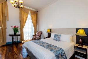 昆卡公园酒店及套房的卧室配有床、椅子和窗户。