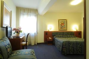 科内利亚诺克里斯塔罗酒店的酒店客房设有两张床、一张书桌和一个窗户。