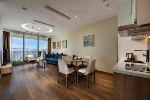 吉婆岛Flamingo Premium Cat Ba Beach Resort的厨房以及带桌子和沙发的客厅。
