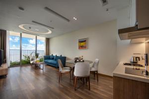 吉婆岛Flamingo Premium Cat Ba Beach Resort的客厅配有桌子和蓝色沙发