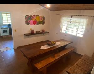 塞拉内格拉Recanto da Natureza的一间客房内配有木桌的房间