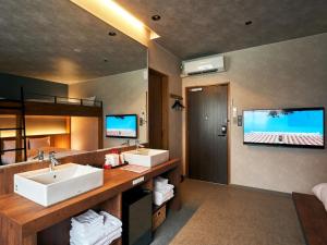 那霸Rakuten STAY Naha-Miebashi Bunk bed Room的一间带两个盥洗盆的浴室和一台平面电视