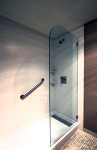 奥克兰奥克兰行政酒店&套房的浴室里设有玻璃门淋浴