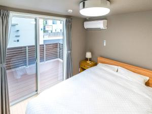 高崎Rakuten STAY HOUSE x WILL STYLE Takasaki 102的一间卧室设有一张床和一个阳台