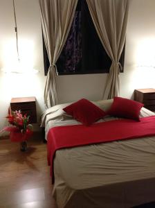 帕皮提ROYAL VAI的一间卧室配有两张带红色枕头的床