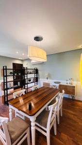 十月六日城Sodic Westown Residence 2的一间带木桌和白色椅子的用餐室