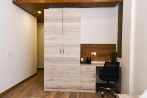 古尔冈Stay Studio Hotel & Residences的办公室设有木制衣柜和书桌