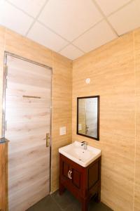 古尔冈Stay Studio Hotel & Residences的一间带水槽和木墙的浴室