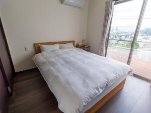 佐世保Rakuten STAY HOUSE x WILL STYLE Sasebo 109的一间卧室设有一张大床和大窗户