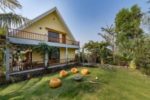 浦那SaffronStays Happy Fields, Pune - luxury farmstay with farm to table food的草坪上带南瓜的房子