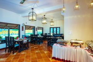 KaliyalVaikundam Legacy的用餐室配有桌椅和吊灯。