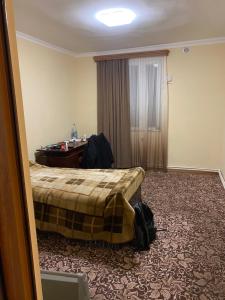 埃里温Friend's House rooms near Airport的配有一张床和一张书桌的酒店客房