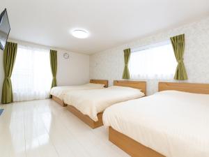 日光Kinugawa Station Front room A的一间卧室设有两张床,窗户配有窗帘
