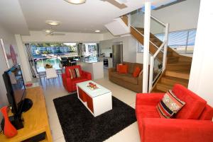 耐莉湾海滨磁力海港公寓式酒店的一间带红色家具和楼梯的客厅