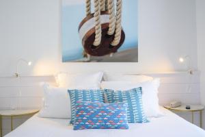 圣马丹德雷杰特酒店的一张带白色枕头的床和一张墙上的照片