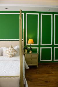 斋浦尔Dileep Kothi - A Royal Boutique Luxury Suites in Jaipur的一间卧室配有一张带绿色墙壁的床