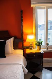 斋浦尔Dileep Kothi - A Royal Boutique Luxury Suites in Jaipur的一间卧室配有一张床和一张带台灯的桌子