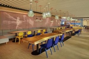 吉隆坡吉隆坡市中心智选假日酒店的餐厅设有木桌和蓝色椅子
