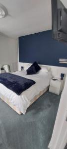 LaurièreSycamore House的一间卧室设有一张蓝色墙壁的大床