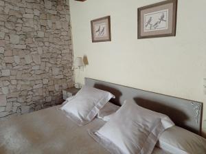 FortiáCan Bayre-Casa Rural的一间卧室配有一张带两个枕头的床和石墙