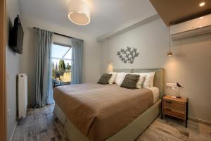科孚镇Efilenia Luxury Villas的一间卧室设有一张大床和一个窗户。