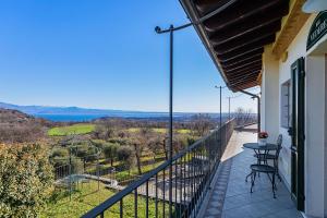 纳托Garda Country House by Wonderful Italy的阳台,配有桌椅
