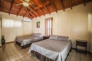 罗阿坦Relaxing Tropical Cabin的一间卧室配有两张床和吊扇
