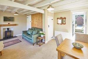 LocktonHost & Stay - Holmlea Cottage的客厅配有沙发和桌子