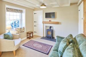 LocktonHost & Stay - Holmlea Cottage的带沙发和壁炉的客厅