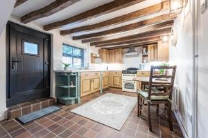 奥勒顿Bieldside Cottage的厨房配有木制橱柜和黑色门