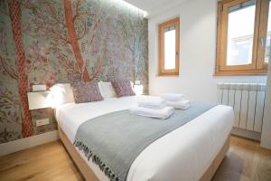 马德里Smartr Madrid Gran Via Apartments的一间卧室配有带毛巾的床