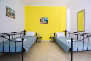 伊利索斯CHAMBRE JAUNE的黄色墙壁的客房内的两张床