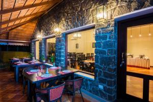 KaliyalVaikundam Legacy的一间带桌椅和石墙的餐厅