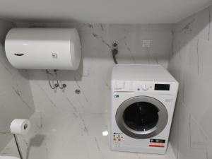 波德戈里察Blue Apartment Riverside的一间带卫生间的浴室内的洗衣机